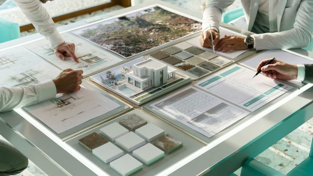 Immobilienberatung in Montenegro - Drei Personen prüfen Architekturpläne, Materialmuster und ein Gebäudemodell.